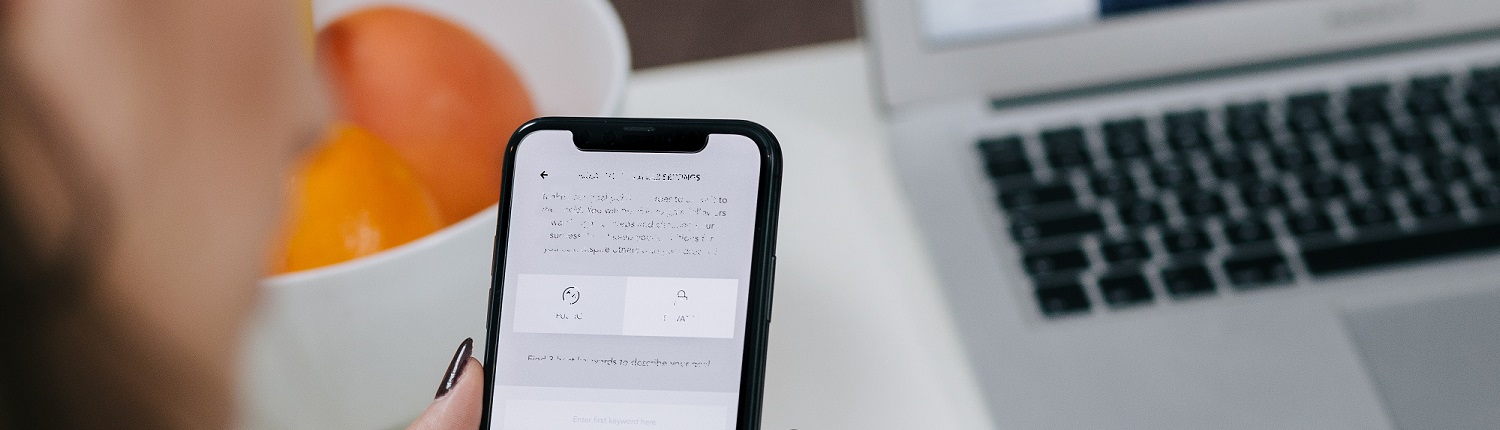 Banner women-holding-space-gray-iphone-x-and-black-pen-744461